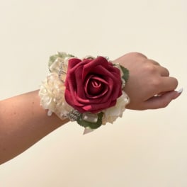 Red rose wrist corsage with cream ribbon and rhinestone accents