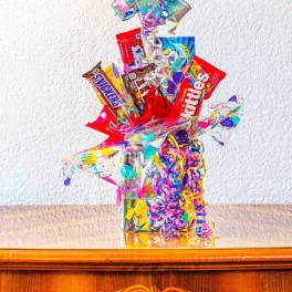 Birthday balloon and candy gift arrangement with colorful ribbons