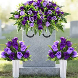 Purple rose funeral arrangement on a gravestone with two matching vase bouquets