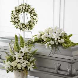 White floral funeral casket spray, wreath, and basket arrangement