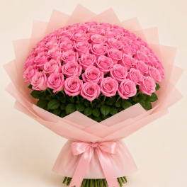 Large bouquet of pink roses wrapped in pale pink paper with a satin bow