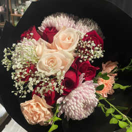 Bouquet of red and blush roses with pale pink chrysanthemums and carnations