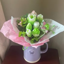 Bouquet of green and white tulips in a lavender mug vase