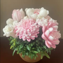 Pink and white flower arrangement in a round pot