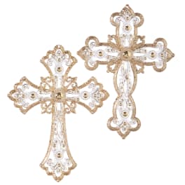 Two ornate gold and white decorative crosses on a white background