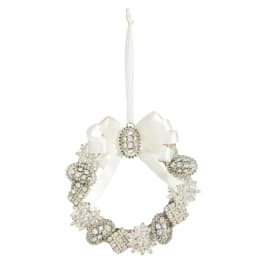 White decorative wreath ornament with a ribbon bow and hanging loop
