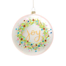 Round ornament with a leafy wreath and the word "joy" in gold script