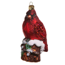 Red bird ornament perched on a snow-covered log