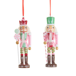 Two colorful nutcracker ornaments hanging on red ribbons