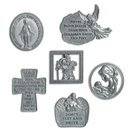 Assorted silver religious car visor clips and medallions on a white background