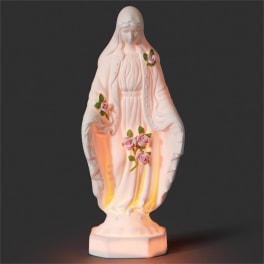 White religious statue with small pink roses on a dark background