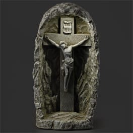 Stone crucifix with a carved figure of Jesus in a rock-like niche