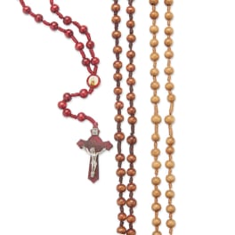 Three rosary necklaces with wooden beads and crucifixes on a white background