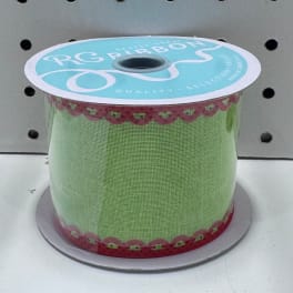 Spool of green ribbon with red trim on a display reel