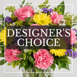 Mixed bouquet of pink roses, carnations, and yellow daisies in a glass vase