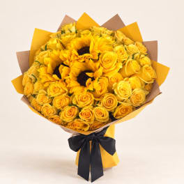 Bouquet of yellow roses and sunflowers wrapped in yellow and brown paper