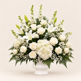 White roses and lilies arranged in a white vase