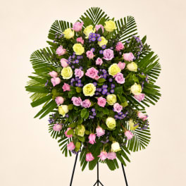 Standing floral spray with pink and yellow roses and purple filler flowers