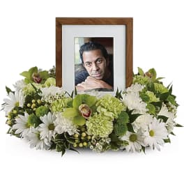 White and green floral frame around a photo in a wooden frame