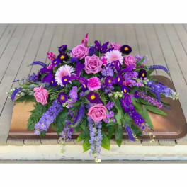 Purple and pink floral arrangement on a tray