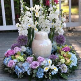 White floral wreath with lavender roses and a ceramic urn centerpiece