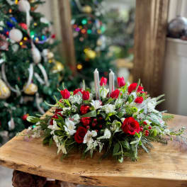 Red roses and white flowers arranged with silver candles
