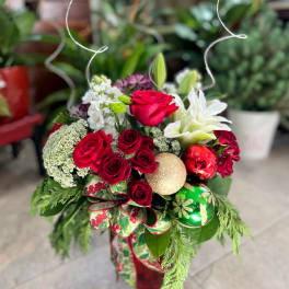 Holiday bouquet with red roses, white lilies, and Christmas ornaments