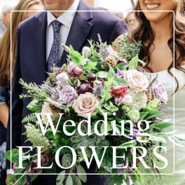 Wedding bouquet of blush and lavender roses with mixed greenery