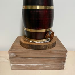 Wooden barrel-style dispenser on a rustic wooden box base