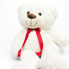 White teddy bear with a red ribbon bow