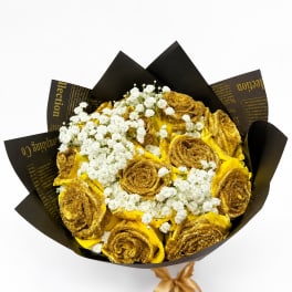 Bouquet of gold roses and white baby's breath in black wrapping