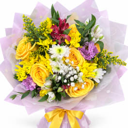 Mixed bouquet of yellow, white, purple, and red flowers wrapped in lavender paper