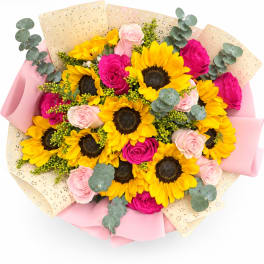 Bouquet of sunflowers and pink roses wrapped in pink and beige paper