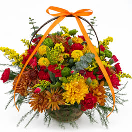 Basket of red, yellow, and orange flowers with an orange ribbon handle