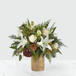 White lilies and roses in a gold vase with pinecones
