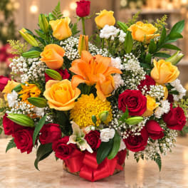 Mixed bouquet of red and yellow roses with lilies in a basket