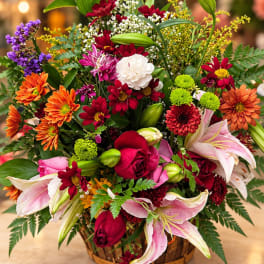 Mixed bouquet with lilies, roses, and daisies in a basket