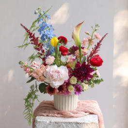 Colorful mixed flower arrangement in a white ribbed vase