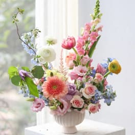 Colorful mixed flower arrangement in a white vase
