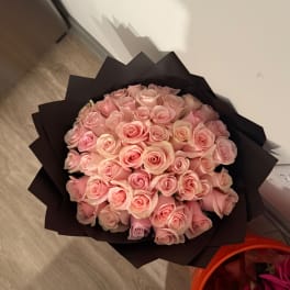 Bouquet of pale pink roses wrapped in black paper