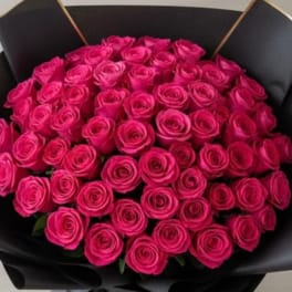 Bouquet of bright pink roses wrapped in black paper