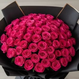 Bouquet of bright pink roses wrapped in black paper