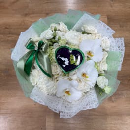 White bouquet with orchids and roses wrapped in mint and white paper