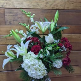 White lilies, white hydrangea, and burgundy roses in a glass vase