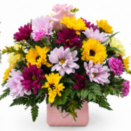 Mixed pink, yellow, and purple flowers in a pink vase