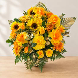 Yellow roses and sunflowers arranged in a vase