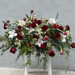 Large red and white floral arrangement with roses and orchids