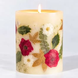 Floral-decorated pillar candle with a lit flame
