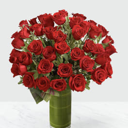 Bouquet of red roses in a tall glass vase