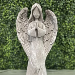 Stone angel figurine with folded hands and wings